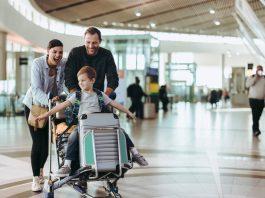 Couple pushing trolley with their child at airport